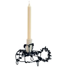 a white candle sitting on top of a metal holder with black chains around it's edges