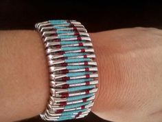 a woman's arm with a bracelet made out of silver and red beads on it