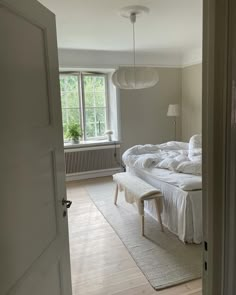 a bed sitting in the middle of a bedroom next to a doorway with a window