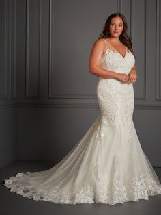 a woman in a wedding dress posing for the camera with her hands on her hips