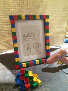 a child playing with legos in front of a framed picture frame that says 4x6