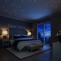 a bed room with a neatly made bed under a sky filled with stars and the words sweet dreams above it