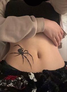 a person with a spider tattoo on their stomach