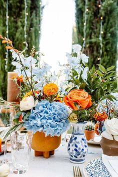 the table is set with blue and orange flowers