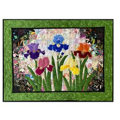 a quilted wall hanging with colorful flowers on it's side and green border