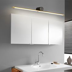 a white bathroom sink sitting under a mirror next to a wall mounted faucet