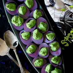 there are some cupcakes with green frosting on them and two spoons next to it