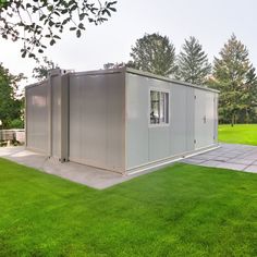 a portable home in the middle of a grassy area with trees and grass around it