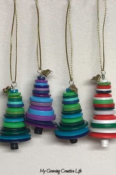 four different colored wooden christmas trees hanging from chains