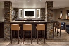 two bar stools sit in front of a television mounted on the wall behind them