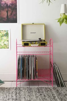 a record player is sitting on top of a shelf next to a wall with records