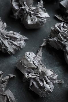 several pieces of cloth that are sitting on a counter top, with some torn off fabric around them