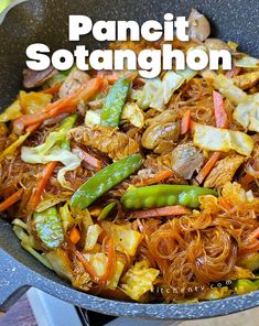 a pan filled with noodles and vegetables on top of a stove