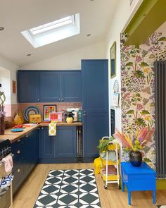 a kitchen with blue cabinets and an area rug on the floor in front of it