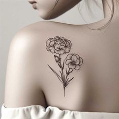 the back of a woman's shoulder with flowers tattooed on her left arm and chest