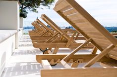 a row of wooden lawn chairs sitting next to each other