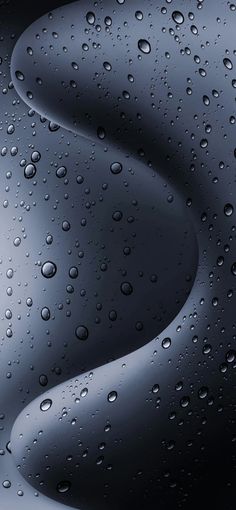 drops of water on the surface of a dark blue and black wallpaper with wavy lines