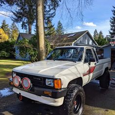 a white pick up truck parked in front of a house