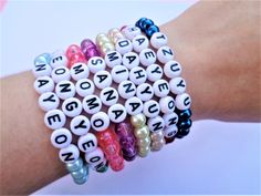 several bracelets with letters and pearls on them