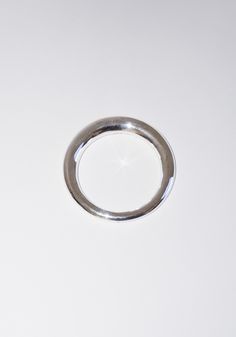 a silver ring sitting on top of a white surface