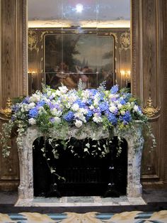 a fireplace decorated with blue and white flowers