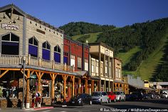 the town has many shops and stores along it's sides, with mountains in the background