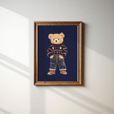 a teddy bear wearing a sweater and jeans is framed in a wooden frame on the wall