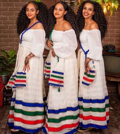 three beautiful women standing next to each other