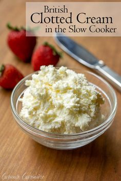 a bowl filled with whipped cream next to strawberries