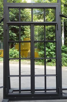 an open metal door in front of some trees