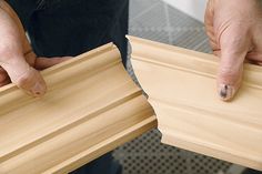 two hands holding wooden pieces of plywood