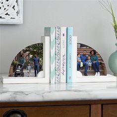 two books are sitting on top of a table with an image of people in the background