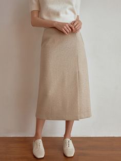 This product is a sophisticated wool skirt, designed with a sleek, midi-length cut that offers a modern take on classic styling. The skirt's high waist and straight silhouette provide a flattering fit, while the wool material ensures warmth and comfort. The high-waisted design is both flattering and practical, providing a comfortable fit that's ideal for all-day wear.Its straight cut and midi length create a streamlined look that's versatile for office wear or formal events.Crafted from qua Wool Midi Skirt For Workwear, Tailored Chic Wool Skirt, Chic Tailored Wool Skirt, Elegant Wool Midi Skirt, Tailored Wool Skirt Chic Style, Beige Formal Midi Bottoms, Formal Beige Midi Length Bottoms, Winter Workwear Bottoms In Midi Length, Spring Long Wool Skirt