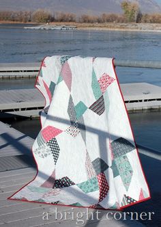 a white quilt sitting on top of a wooden dock