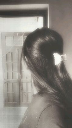 the back of a woman's head with long hair in front of a window