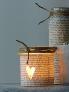 two jars with candles in them sitting on top of a table next to each other