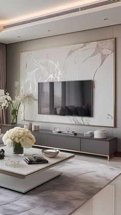 a living room filled with furniture and a flat screen tv mounted on the wall above it