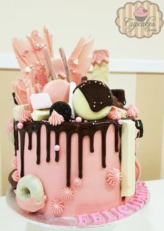 a pink cake with chocolate icing and decorations