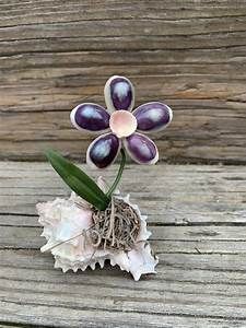 a small purple flower sitting on top of a wooden table