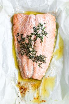 a piece of salmon with herbs on it