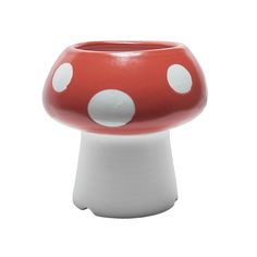 a red and white mushroom shaped vase with polka dots on the top, sitting in front of a white background