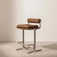 a chair with a leather seat and metal frame in an empty room on the floor