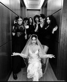 black and white photograph of bride in elevator surrounded by her bridesmaids wearing masks