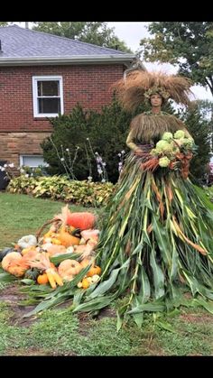 a woman is dressed up like a scarecrow with pumpkins and gourds