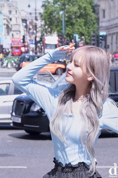 a woman with long hair standing in the street