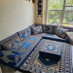 a couch that is sitting in the middle of a room with many rugs on it