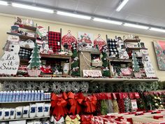 christmas decorations are displayed on shelves in a store's holiday display area, with red and white bows