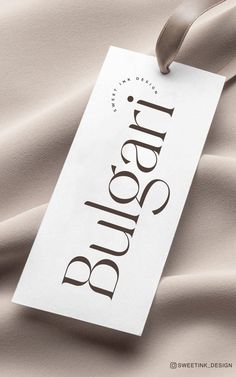 a tag with the word bliss on it laying on a satin material background that is soft and smooth