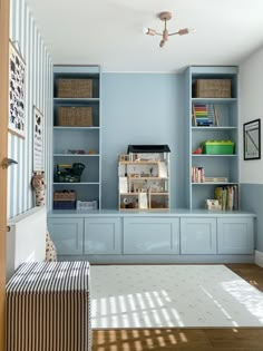 a living room with blue walls and built in bookshelves