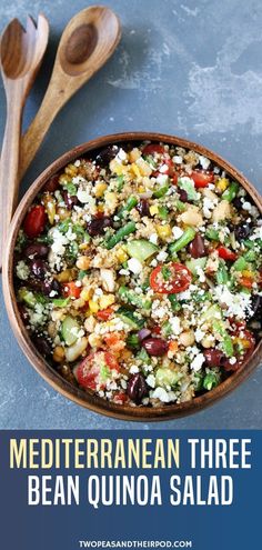 mediterranean bean quinoa salad in a bowl with wooden spoons on the side